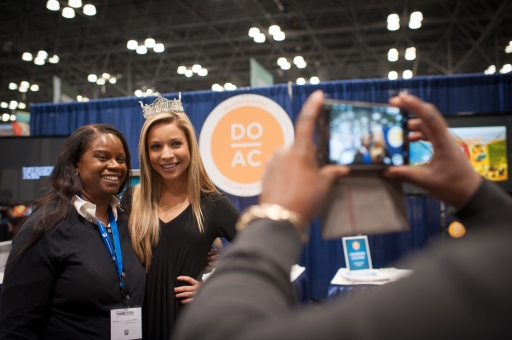 Atlantic City, one of the hundreds of booths at the New York Times Travel Show in Manhattan, offers its visitors a chance to try their luck for prizes and convention swag at the Jacob Javits conference center in Manhattan. Miss America Kira Kazantsev poses for a picture with an attendee. (Jan 23, 2015) Photo by Nancy Borowick